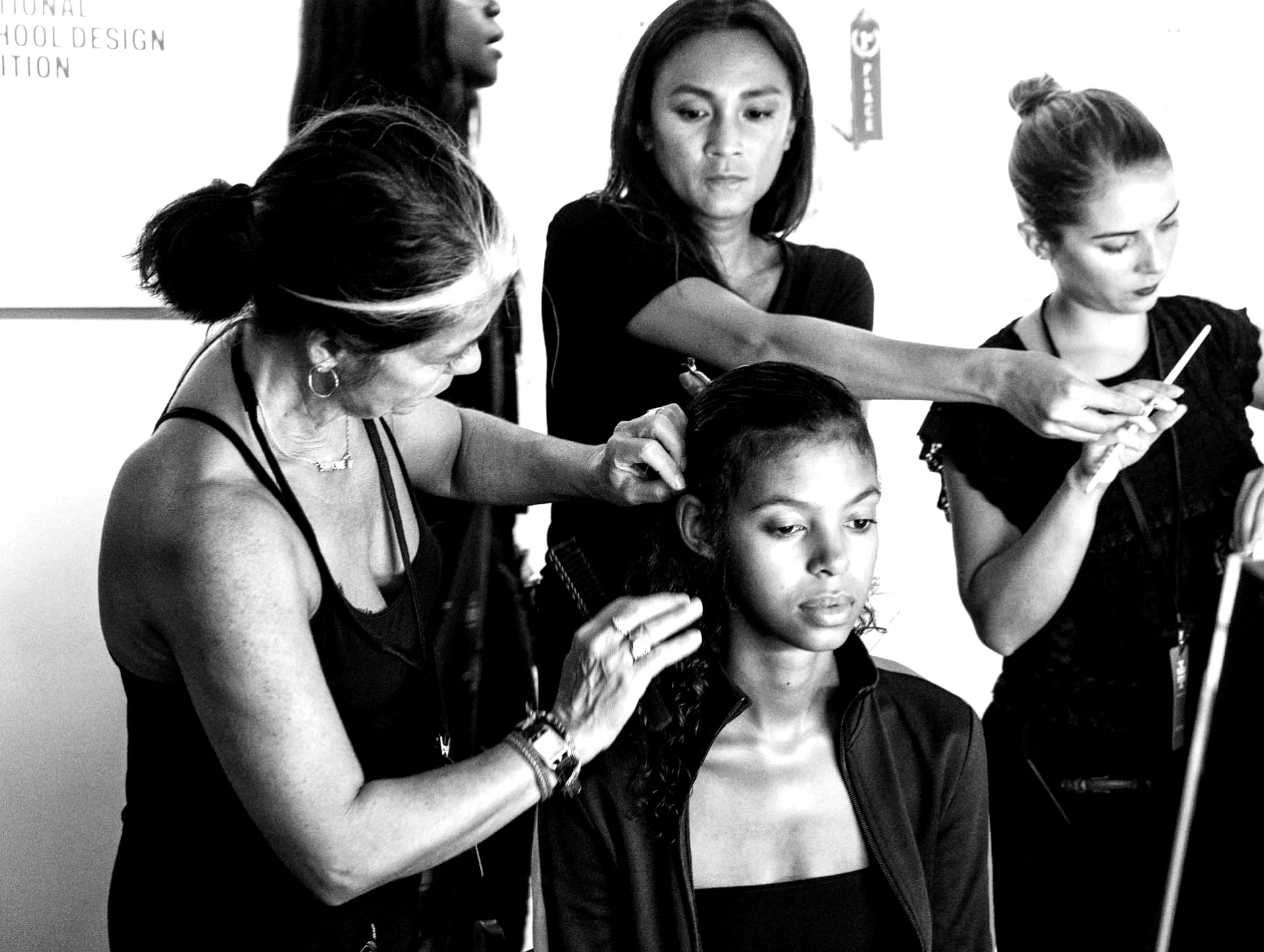 Three stylists working on one model at the same time backstage