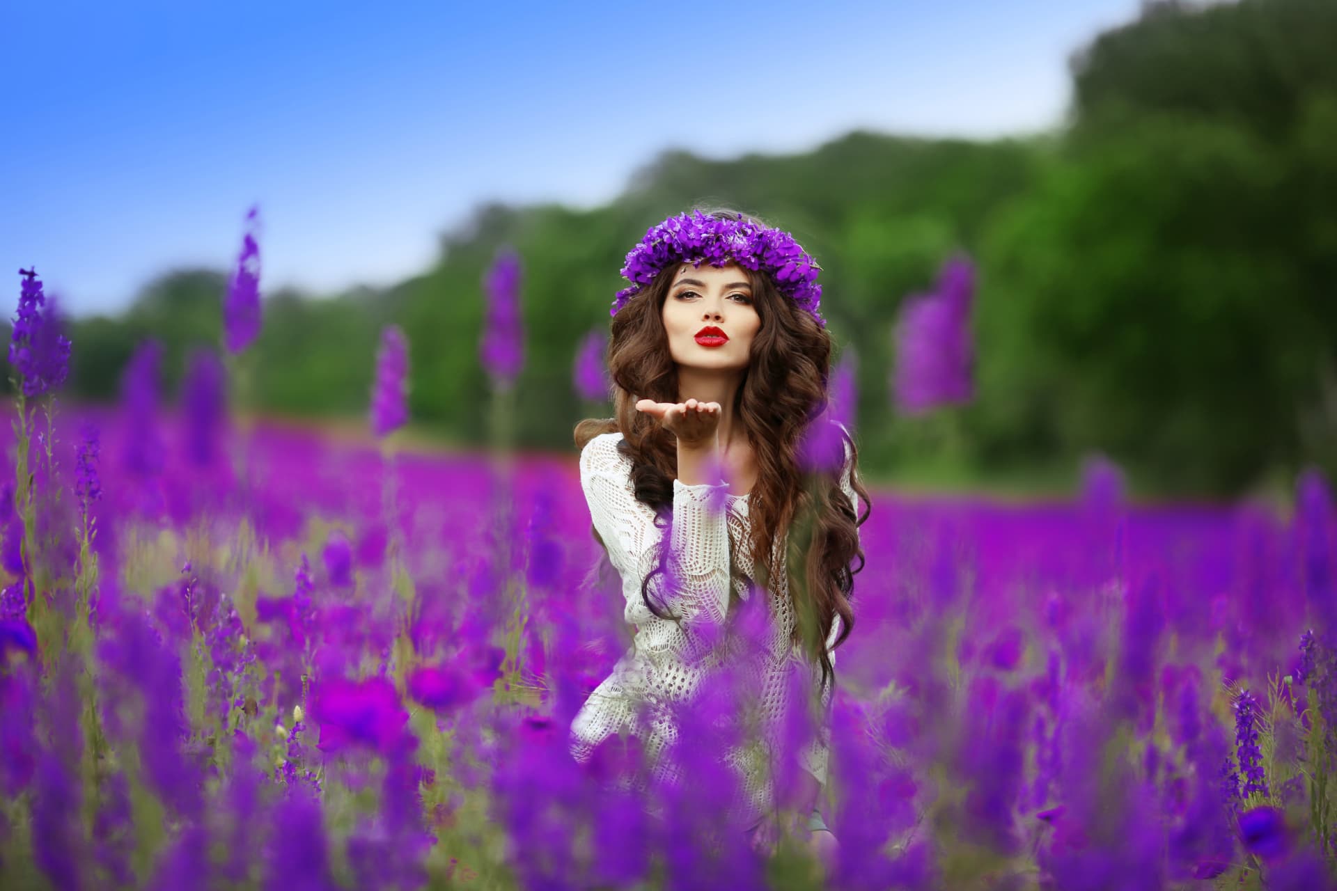 Long, healthy natural hair worn loose in a field of purple flowers